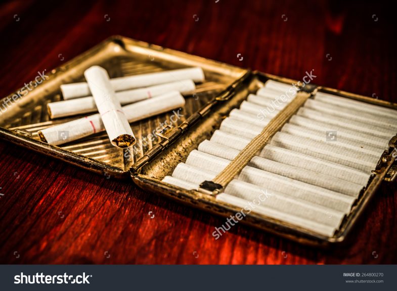stock-photo-old-cigarette-case-with-cigarettes-on-a-table-in-mahogany-image-vignetting-264800270